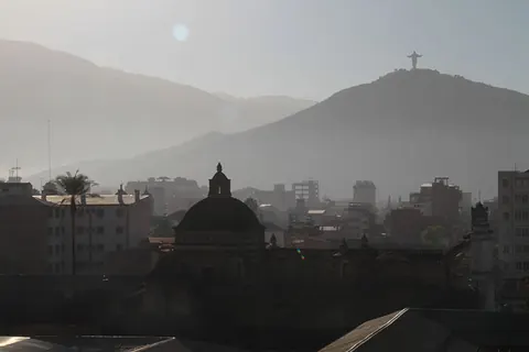A hazy city below a hill with a statue on its summit. Still from Cocaine Prison.