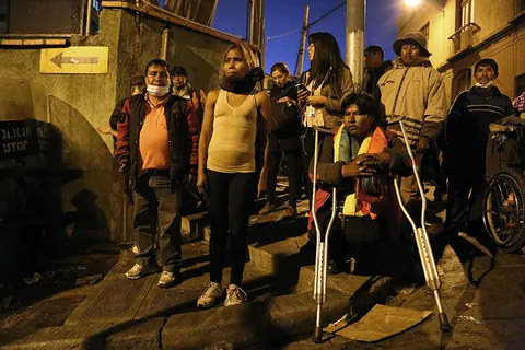 Protesters on crutches and in wheelchairs gather in a street at night. Still from The Fight.
