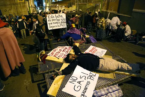 Protesters lie on the ground at night among handwritten signs. Still from The Fight.