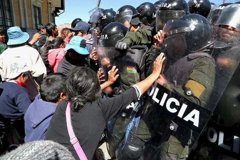 Protesters push against a line of riot police. Still from The Fight.
