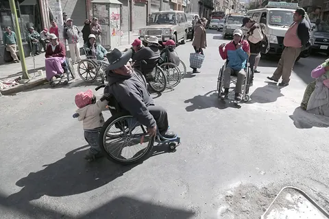 People in wheelchairs move along a city street. Still from The Fight.